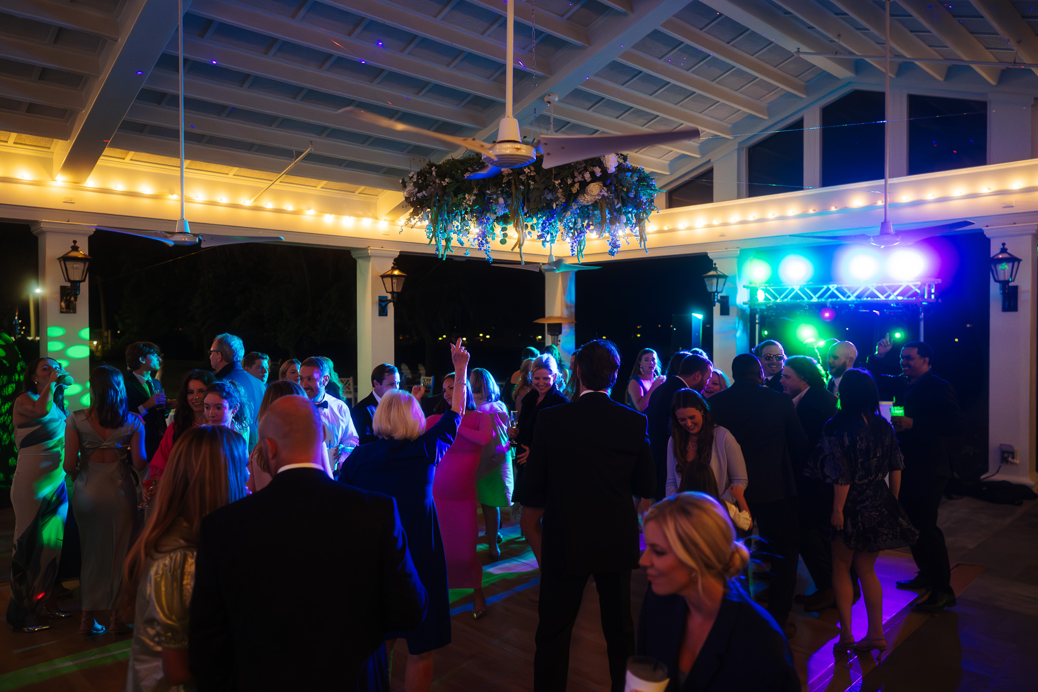 Packed dance floor under DJ laser lighting