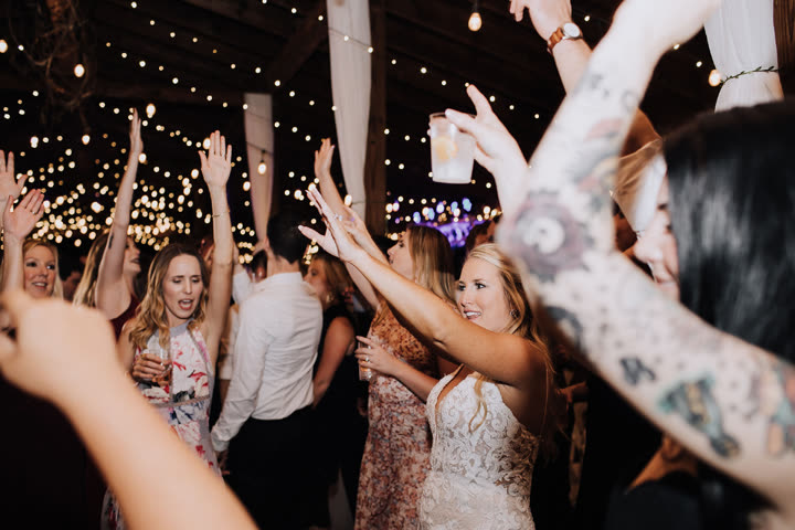 Bride dancing at her wedding reception under DJ lighting